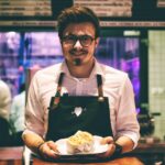 man holding fish dish on plate