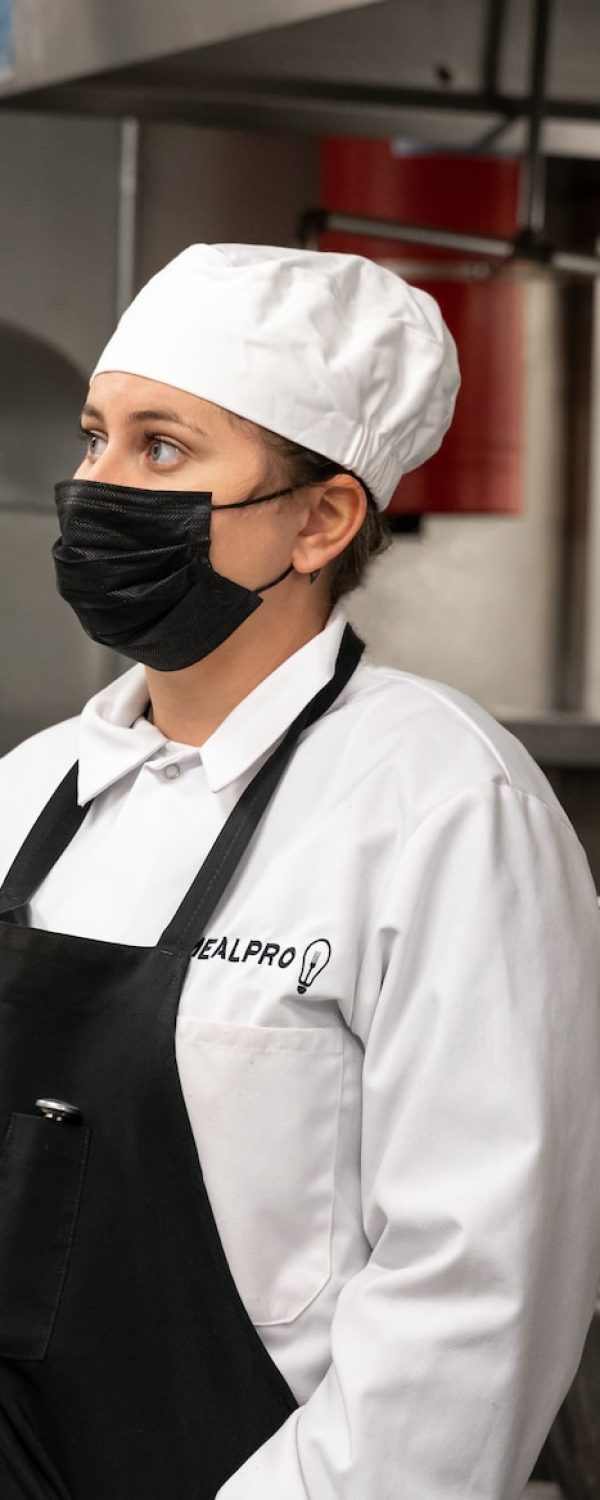 man in white chef uniform standing near stainless steel sink